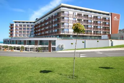 a tree in the grass in front of a building at PARADISO 'В' 609 Studio Nessebar Private in Nesebar