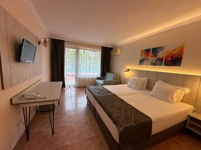 a hotel room with a bed and a table at Oleander House and Tennis Club in Sunny Beach