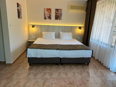 a bedroom with a bed with white sheets and pillows at Oleander House and Tennis Club in Sunny Beach