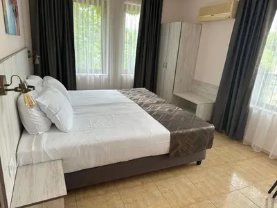 a bedroom with a bed with white sheets and pillows at Oleander House and Tennis Club in Sunny Beach