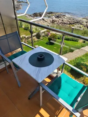 a table and chairs on a balcony with the ocean at Guest Rooms Skalite in Sozopol