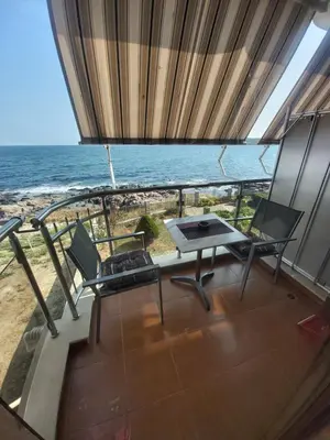 a balcony with a table and chairs and the ocean at Guest Rooms Skalite in Sozopol