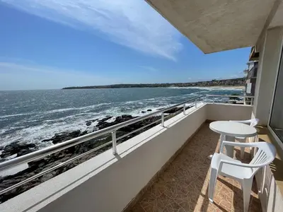 a balcony with a table and two chairs and the ocean at Свети Никола in Sozopol