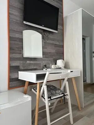 a white desk with a tv on a wall at Свети Никола in Sozopol