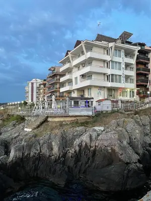 a large building on a cliff next to the water at Свети Никола in Sozopol