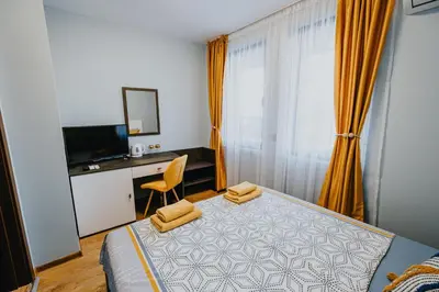 a bedroom with a bed and a desk and a television at Miletia Suites in Sozopol