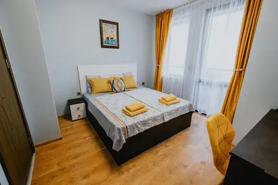 a bedroom with a bed with yellow pillows on it at Miletia Suites in Sozopol