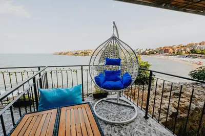 a swing chair on a balcony overlooking the beach at Miletia Suites in Sozopol