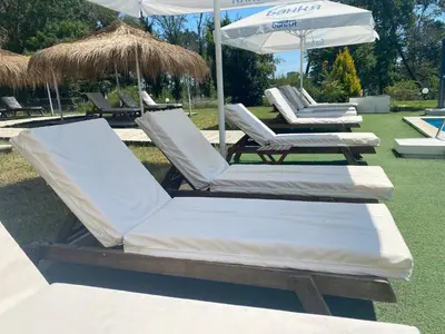 two lounge chairs and an umbrella on a lawn at St. Sofia Beach Hotel in Kiten