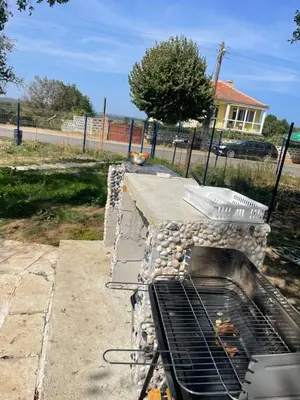 a stone oven in a yard with a fence at Sun Houses Novo Oriahovo in Novo Oryakhovo