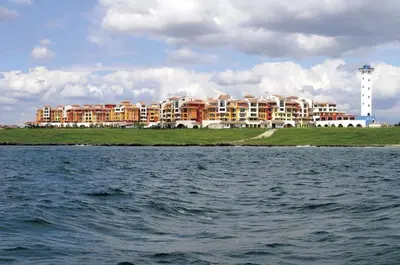 a large building on the shore of a body of water at Hotel Fara - Marina Cape in Aheloy