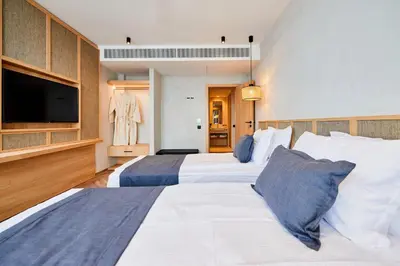 a hotel room with two beds and a flat screen tv at Hotel Fara - Marina Cape in Aheloy