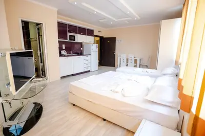 a large bedroom with a large bed and a tv at K&E studios and apartments - All inclusive - Free parking in Sunny Beach