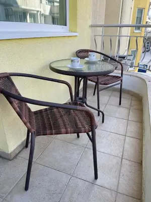 a table and two chairs sitting on a balcony at Апартамент Бриз 16 in Sunny Beach