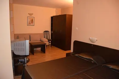 a bedroom with a bed and a living room at Paradise Bay Villas in Sozopol