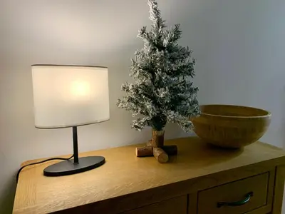 a table with a christmas tree and a lamp on it at Апартамент за гости in Varna City
