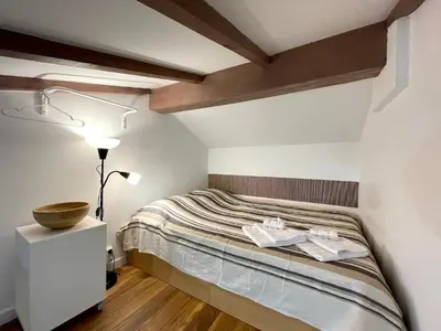 a small bedroom with a bed and a lamp at Апартамент за гости in Varna City