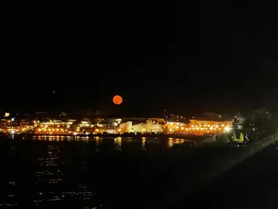 a red moon rising over a city at night at Комплекс Бриз / Breeze Complex Apartments in Sunny Beach