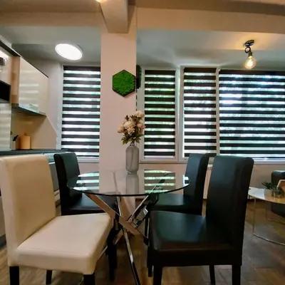 a dining room with a glass table and black chairs at Ika studio in Burgas City