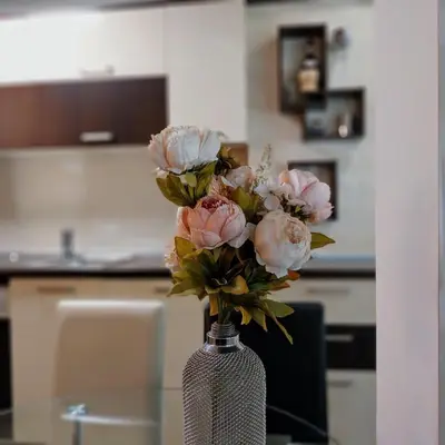 a vase filled with pink flowers on a table at Ika studio in Burgas City