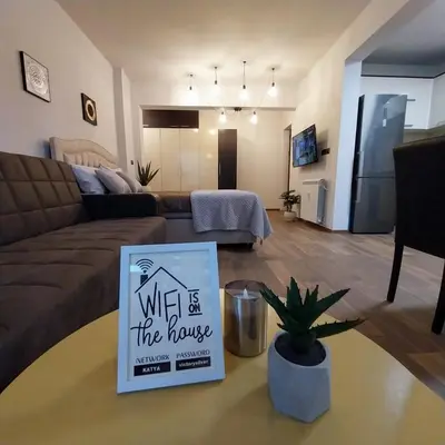 a living room with a couch and a sign that says what is the house at Ika studio in Burgas City