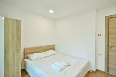 a bedroom with a white bed with towels on it at Hideout in heart of Varna with WiFi in Varna City