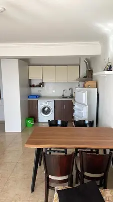 a kitchen with a table and chairs and a refrigerator at Lazur Sea View, Sveti Vlas Beach in Sveti Vlas
