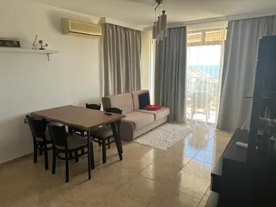 a living room with a couch and a table with chairs at Lazur Sea View, Sveti Vlas Beach in Sveti Vlas