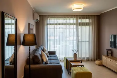 a living room with a couch and a large window at Smokinia Sunrise - Kavatsi Beach, Sozopol in Sozopol
