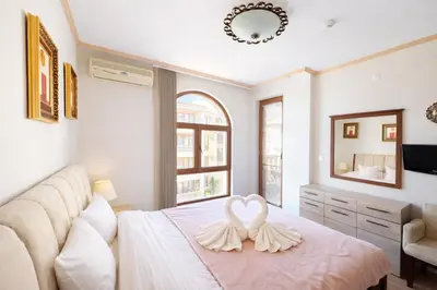 a bedroom with a bed with two white hearts on it at Royal Bay-I Seaview Apartment in Sveti Vlas