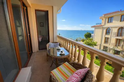 a balcony with a table and chairs and the ocean at Royal Bay-I Seaview Apartment in Sveti Vlas