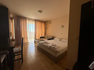 a bedroom with a bed and a couch and a table at Magic Dreams St Vlas in Sunny Beach