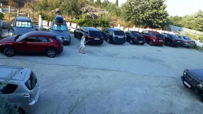 a woman standing in a parking lot with cars at Hotel Gamartata in Duni