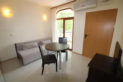 a living room with a table and a couch at Menada Green Hills Apartments in Sozopol
