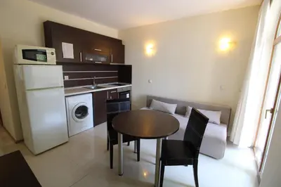 a small kitchen with a table and a laundry room at Menada Green Hills Apartments in Sozopol