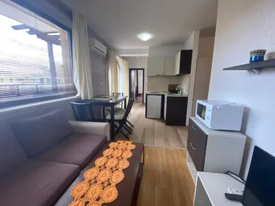 a small living room with a couch and a kitchen at Apartments Amara Sunny Beach in Sunny Beach
