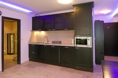 a kitchen with black cabinets and a microwave at Apartments Amara Sunny Beach in Sunny Beach