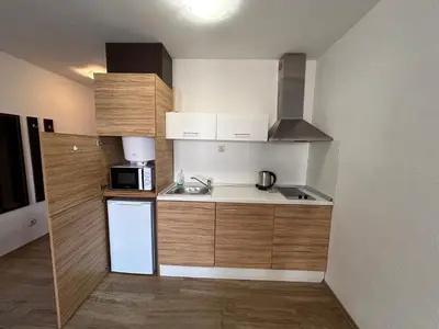 a small kitchen with a sink and a microwave at Apartments Amara Sunny Beach in Sunny Beach
