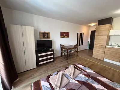 a living room with a television and a dining room at Apartments Amara Sunny Beach in Sunny Beach