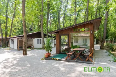 a pavilion with a table and chairs in front of a house at Elmona Villas in Kamchia
