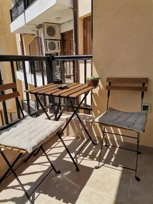 a table and two chairs on a balcony at Апартамент в Oasis beach Kamchia - Лунна пътека in Dolen Bliznak