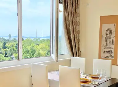 a dining room with a table and chairs and a large window at Alonia - your Burgas shelter by the park and beach in Burgas City