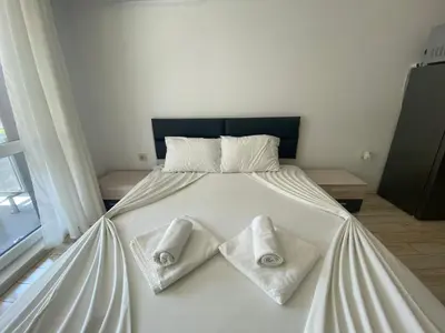 a white bed with two towels on top of it at PARADISO 'В' 111 Large Apartment Nessebar in Nesebar