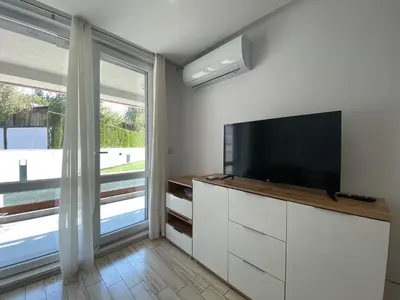 a living room with a tv and a large window at PARADISO 'В' 111 Large Apartment Nessebar in Nesebar