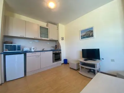 a kitchen with white cabinets and a desk with a computer at AMADEUS 1 - 13B Large Two Bedroom Apartment in Sunny Beach