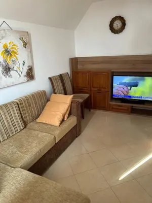 a living room with two couches and a flat screen tv at Голям апартамент с прекрасна гледка кьм морето in Ravda
