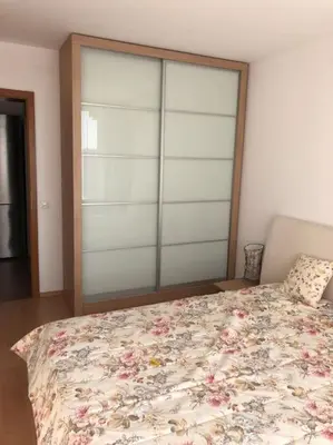 a bedroom with a bed with a floral bedspread at Квартира у моря in Sveti Vlas