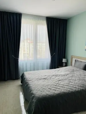 a bedroom with a bed and a large window at Admiral Plaza in Sunny Beach