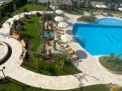 an aerial view of a swimming pool with umbrellas and a resort at Ravda Bliss with a pool in Ravda