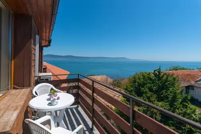 a balcony with a table and chairs and the ocean at Royal Blue Apartments with Sea View in Old Nessebar in Nesebar